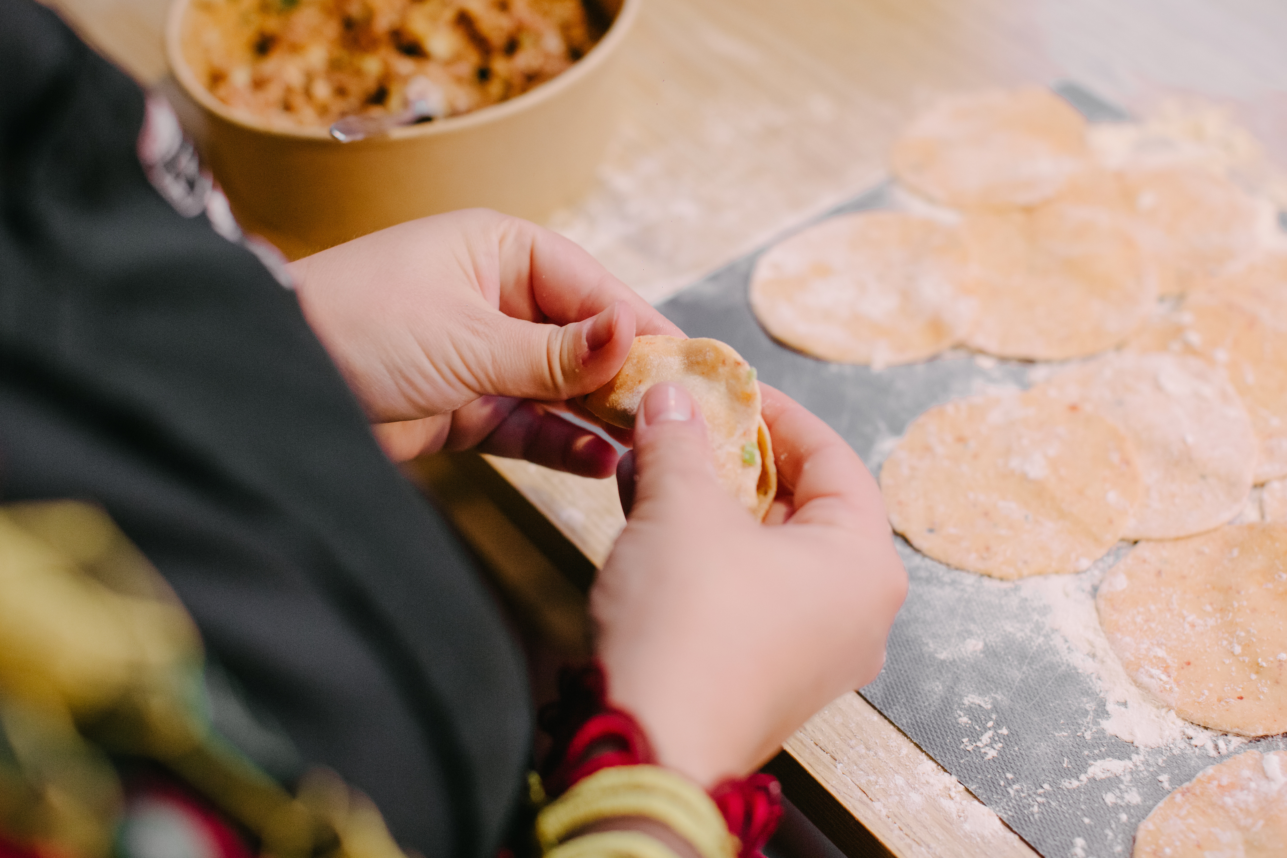 Hands making dumplings in a cooking class